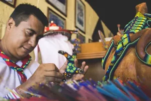 hombre realizando arte huichol